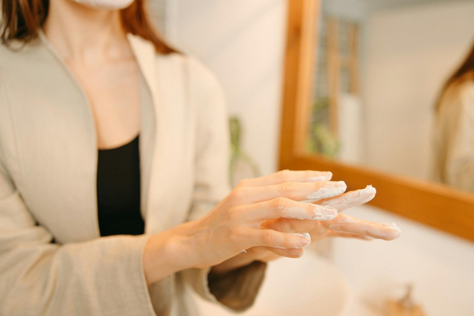 Hands applying ceramide-rich moisturiser to demonstrate barrier-repair skincare application