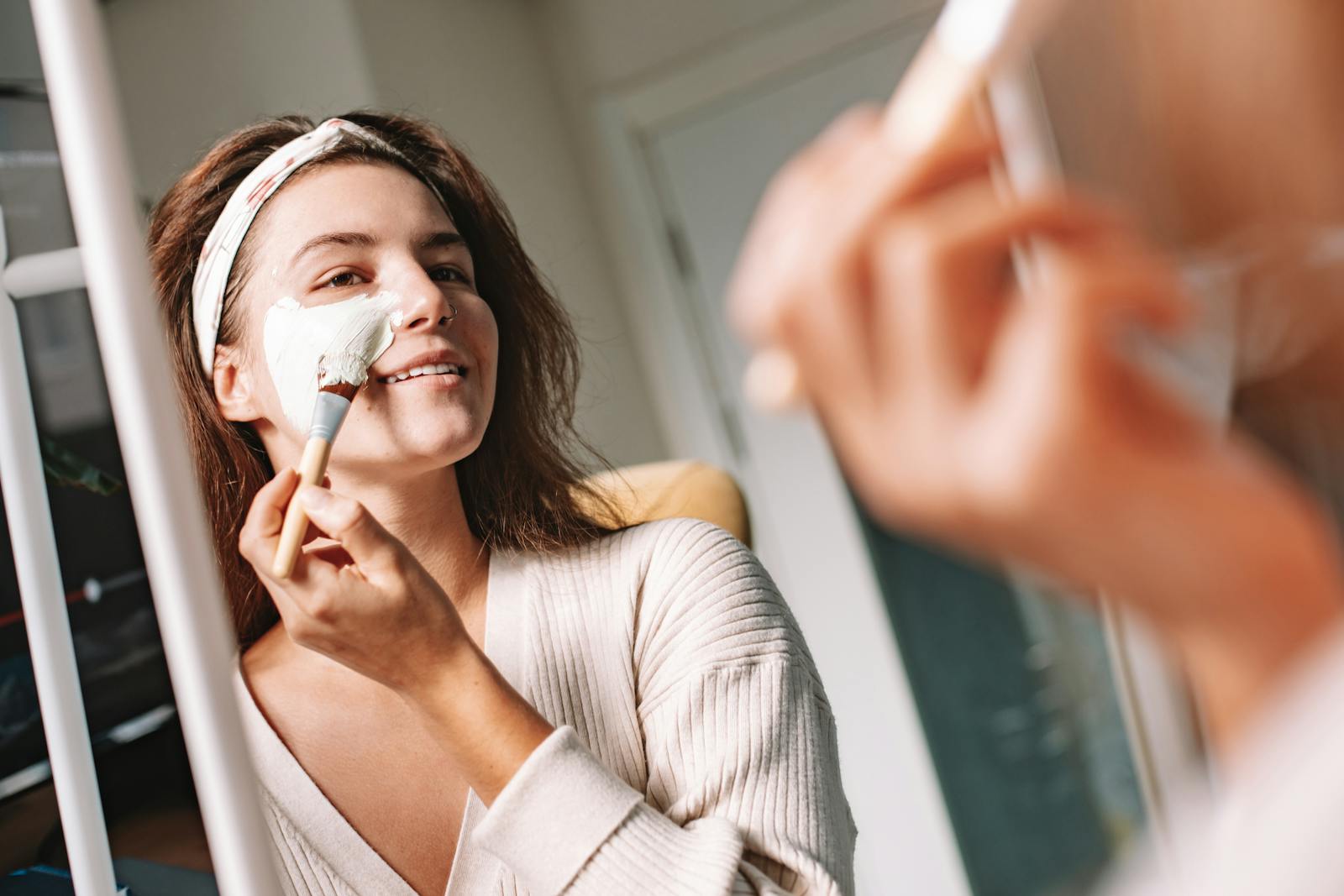 Woman applying a glycolic acid AHA exfoliant during her evening skincare routine