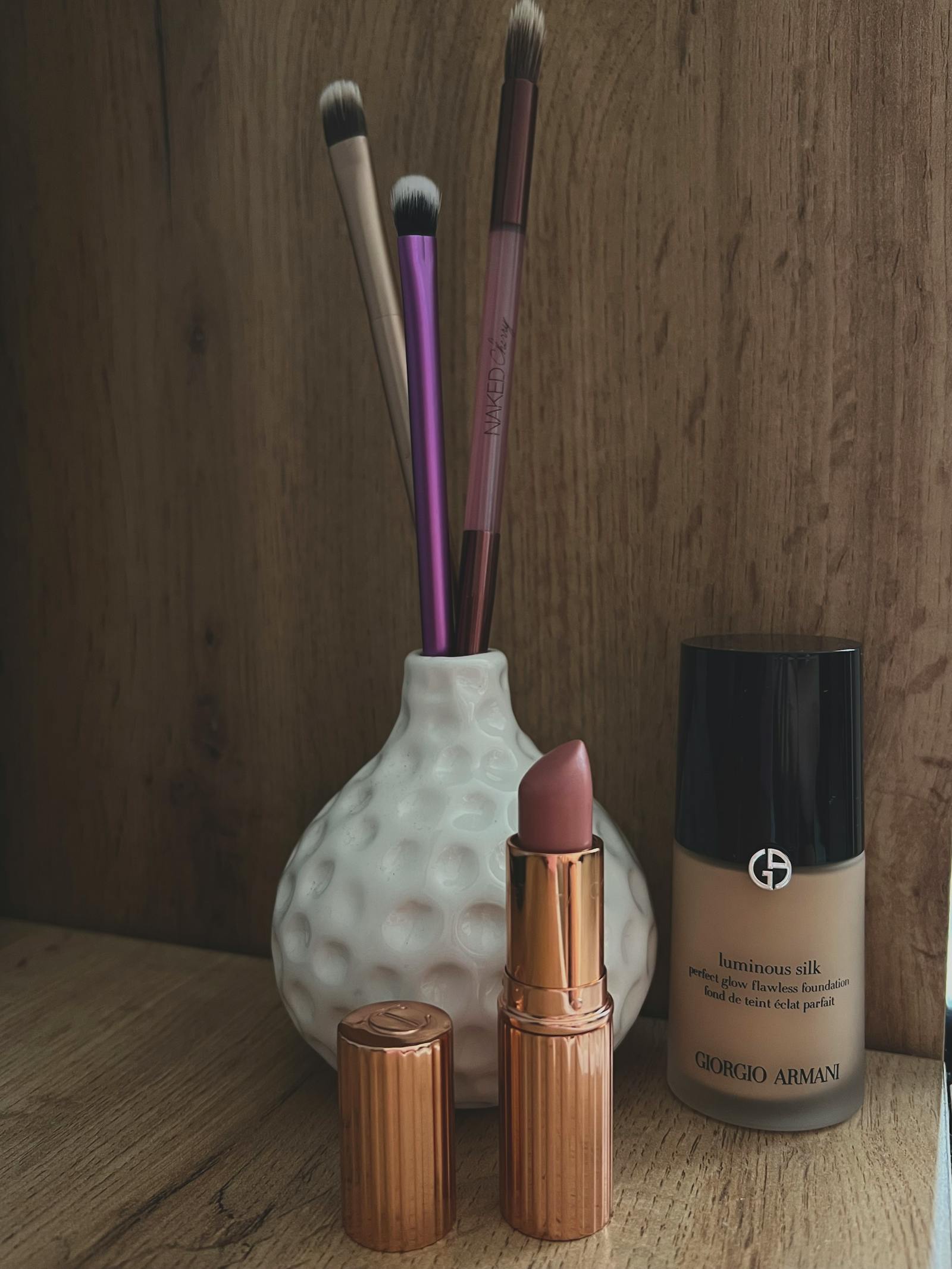 Foundation, mascara and lipstick products in a tidy flatlay, the long-wear makeup categories most affected by the EU PFAS phase-out