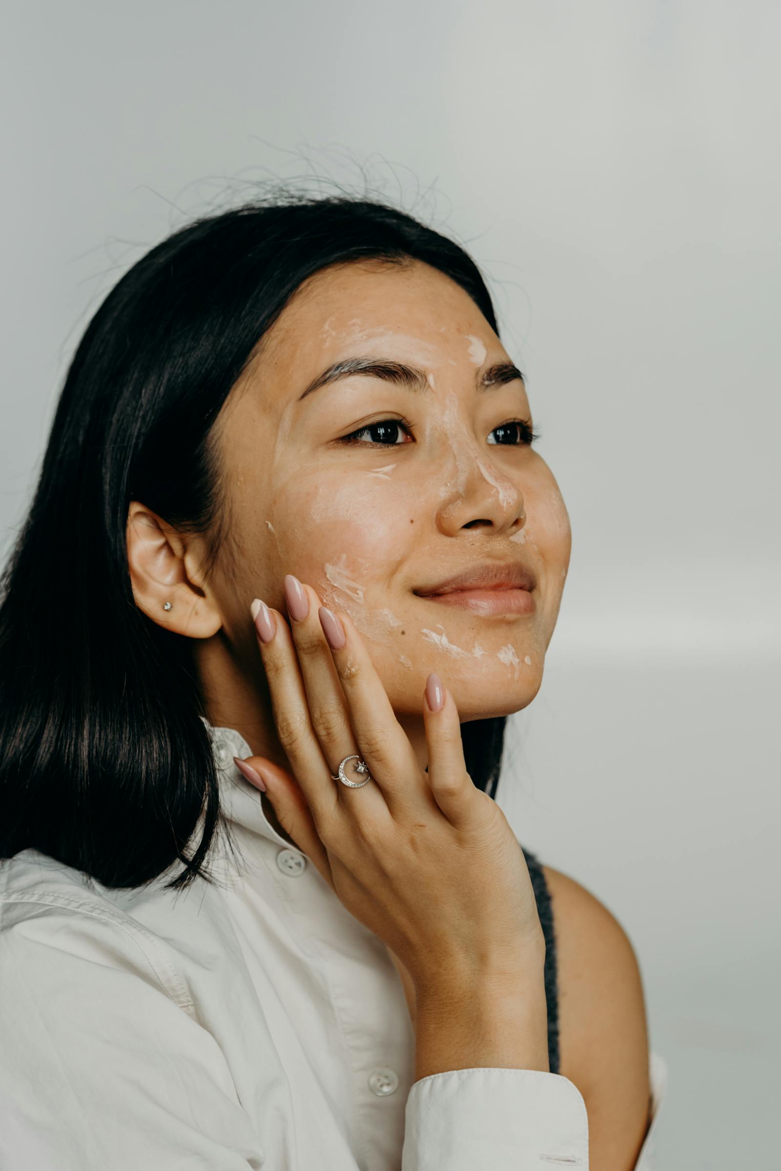 Close-up of a woman applying retinol or exfoliant on an active skin cycling night