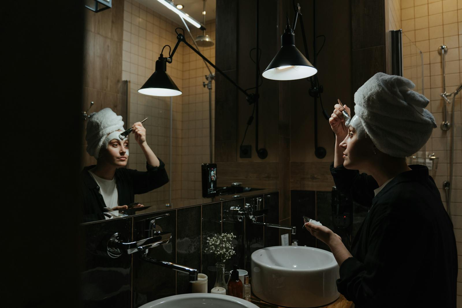Woman in a towel completing her evening skincare in a calm bathroom, the typical pre-slugging set-up