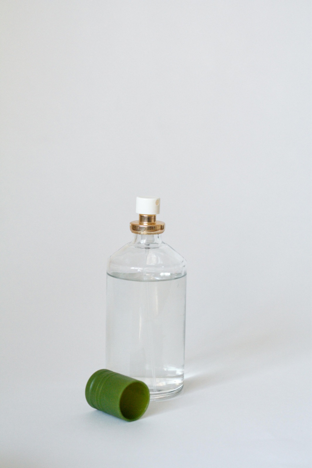 Minimal glass perfume bottle on a neutral surface representing EU parfum disclosure rules for fragrance allergens