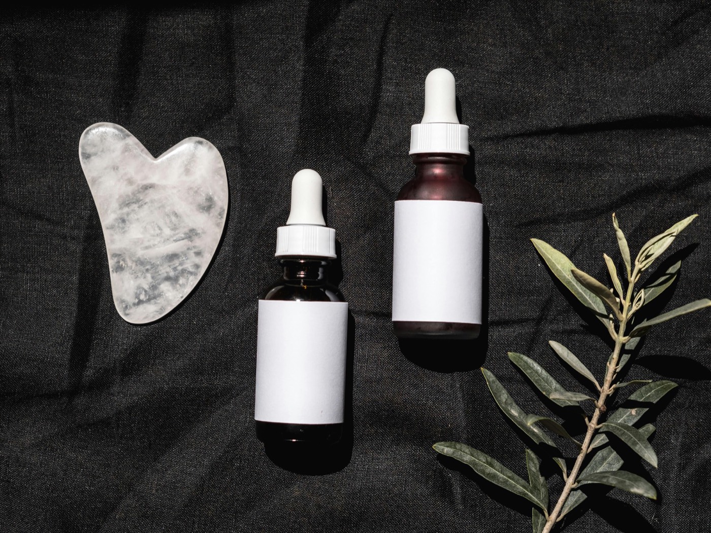 Minimalist skincare flatlay arrangement showcasing a 2026 routine of trending bottles, jars and active ingredients